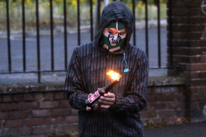 Belfast riots: A masked youth prepares to throw a petrol bomb at police