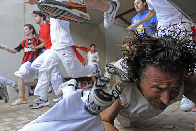 24 hours in pictures: Participants fall to the ground at the San Fermin Festival bull run