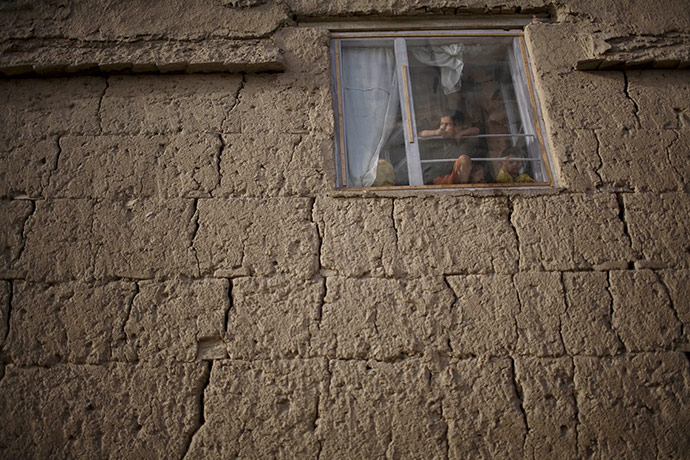 24 hours in pictures: Children look outside though their house window in Kabul, Afghanistan