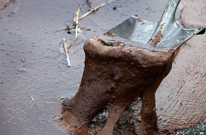 Deepwater Horizon: BP oil spill: An Oil cleanup worker uses a shovel to remove thick oil