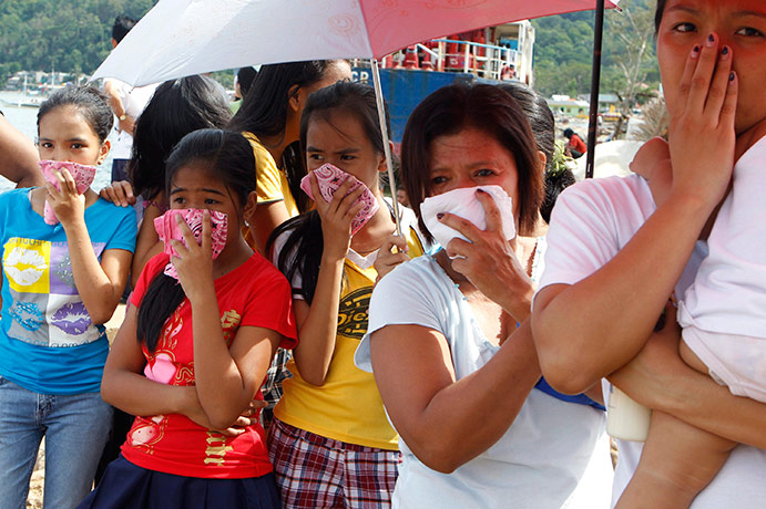 Typhoon Conson: Residents cover their nose near the bodies after Typhoon Conson