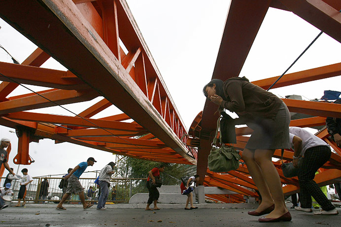 Typhoon Conson: People walk under a construction crane that  collapsed