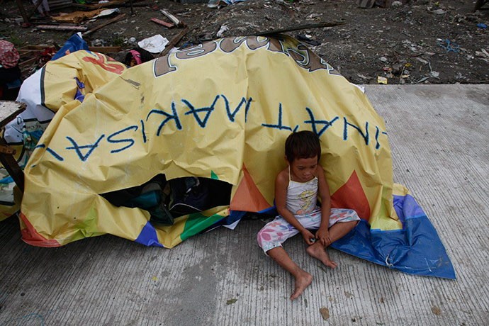 Typhoon Conson: A boy sits amongst his belongings after their shanty in Taytay