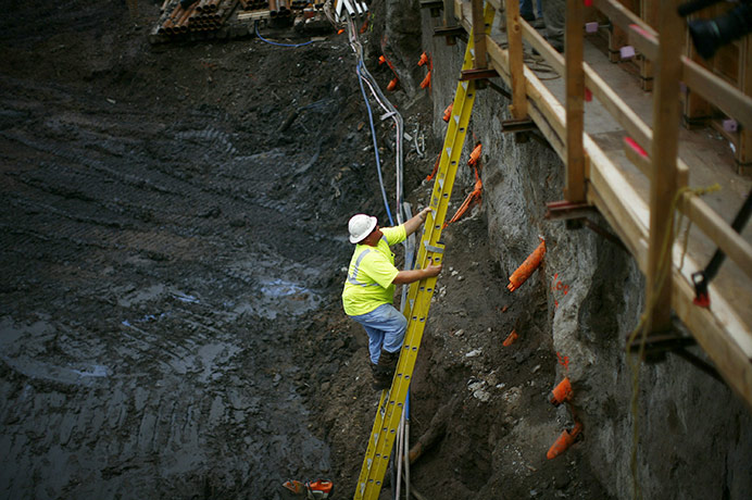World Trade Centre ship: A man climbs a ladder as work continues on the World Trade Centre site