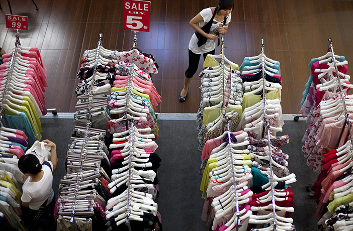 Week in Business: A customer chooses clothes at a shopping mall in downtown Beijing