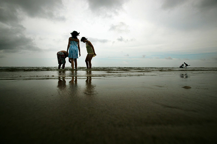 24 Hours in Pictures: Children play on Waveland Beach which had been closed due to the oil spill