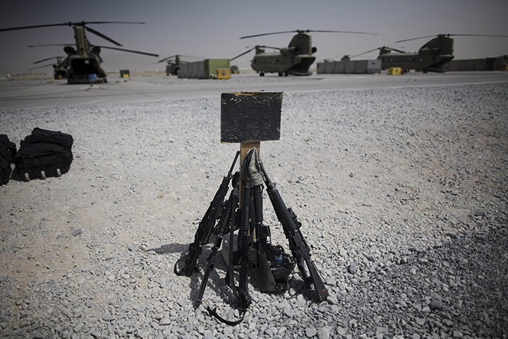 24 Hours in Pictures: Rifles sit at Kandahar Airfield while US soldiers wait to catch a flight