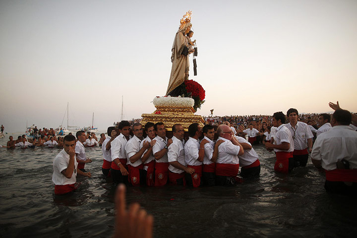 24 Hours in Pictures: Men carry a statue of the El Carmen Virgin into the sea in Malaga
