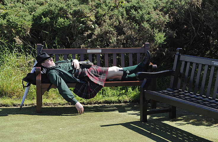 British Open Saturday: A kilt wearing golf fan has a snooze in the sun