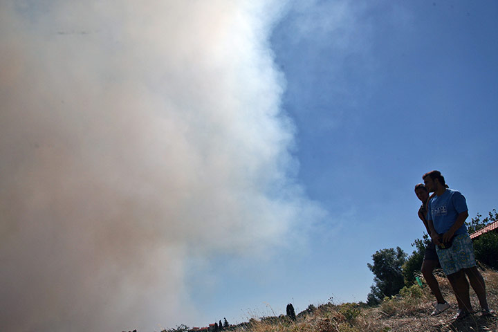 Greece wildfire: Residents of Mikrochori village watch a fire, Greece