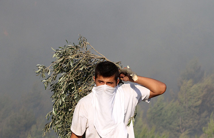 Greece wildfire: A resident protects his face from smoke, Greece