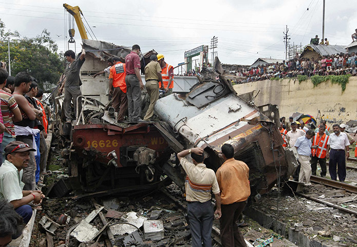 24 hours in pictures: Sainthia, India: Rescue workers and onlookers near the wreckage of a train