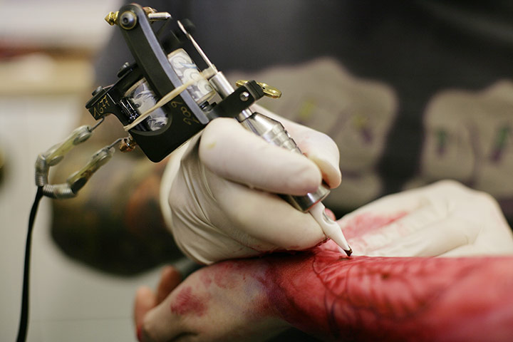 Woody's Tattoo Studio: A tattoo artist in action