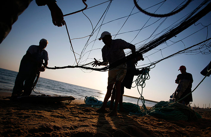 24 hours in pictures: Fishermen prepare their net  along the Caparica coast in Portugal
