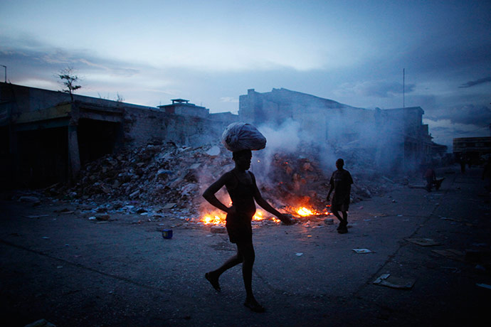 24 hours in pictures: A woman carries a bag on her head Port-au-Prince, Haiti: