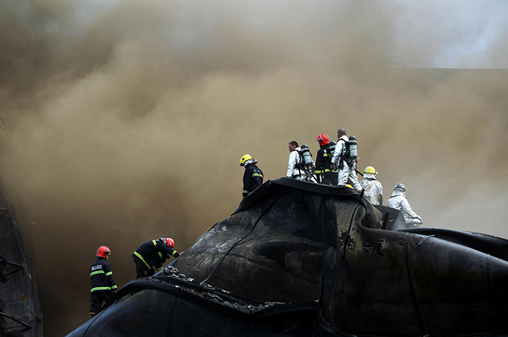24 hours in pictures: Dalian, China: Firefighters after an explosion at a oil storage port