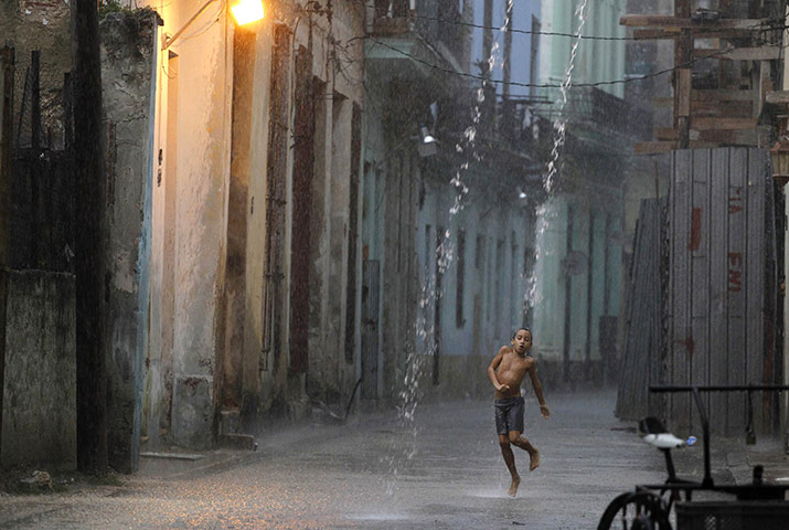 24 hours in pictures: Havana, Cuba: A boy dances in the rain