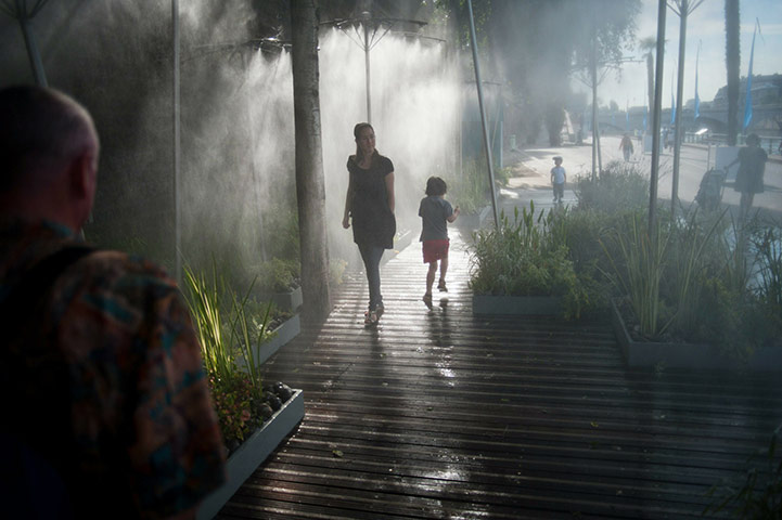 Paris Plage: People stand under water sprays on the opening day of the Paris Plage