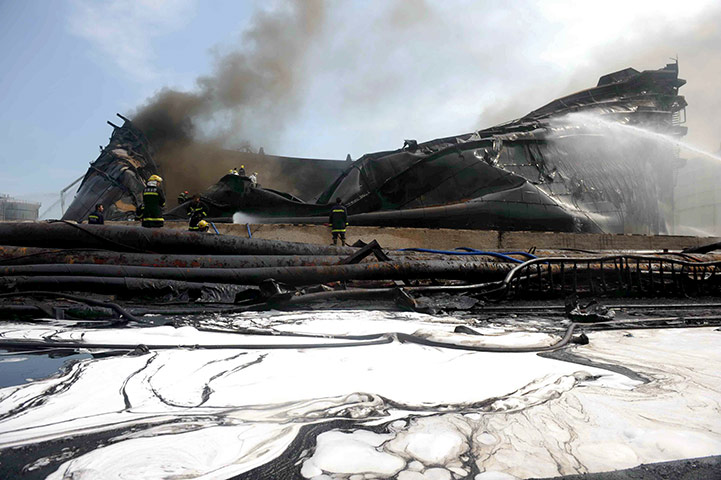 Dalian oil fire in China: Chinese firefighters rest after they ext