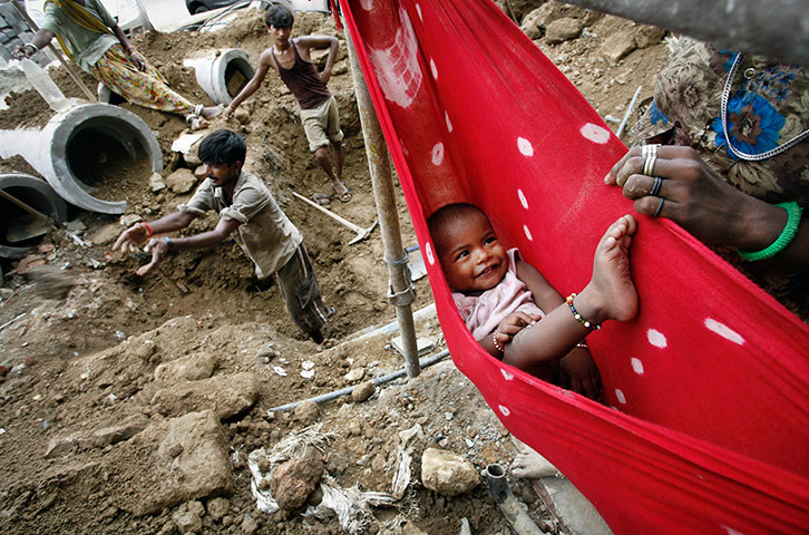 24 hours in pictures: A child lies in a hammock at a construction site in New Delhi, India