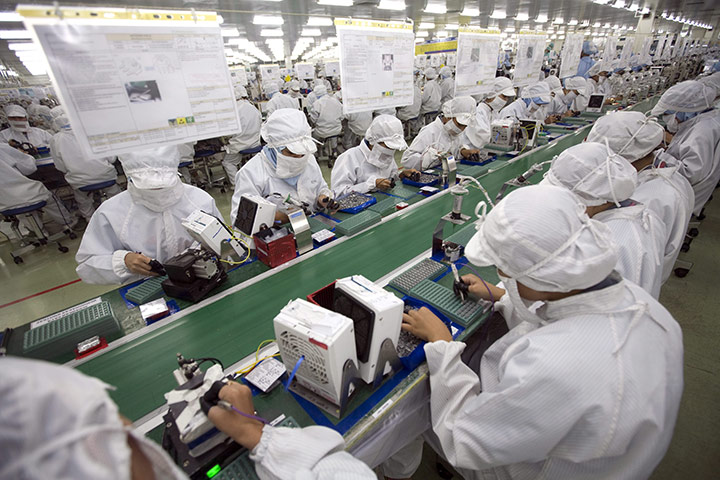 24 hours in pictures: Workers assemble optical lenses at a Japanese electronics company