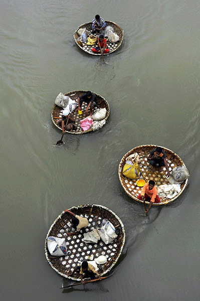24 hours in pictures: People row coracles on a lake in Cochin, India