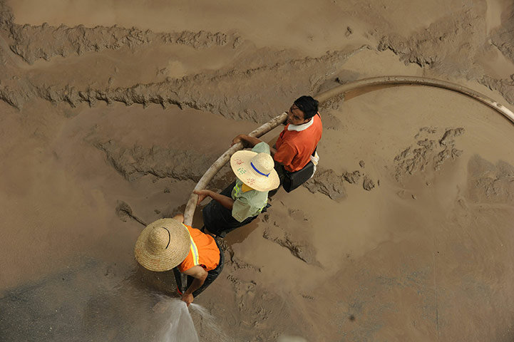 24 hours: Workers clean up mud left by floods on the banks of Yangtze River, China