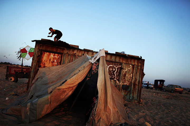 24 hours: A Palestinian woman looks out of a tent set up on the beach