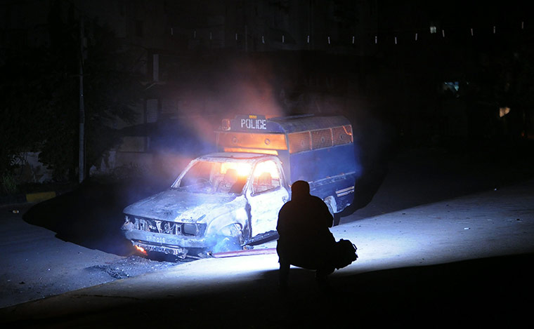 24 hours: A Pakistani cameraman makes a video of a burning police vehicle in Karachi