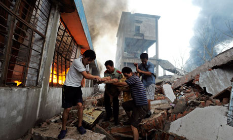 Residents and a firefighter carry a man injured during an explosion at a plastics factory in Nanjing