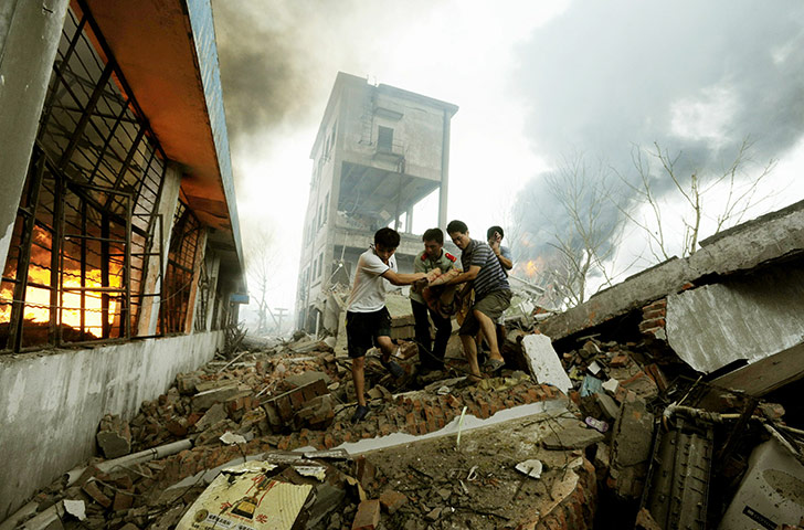 china factory explosion: People carry a wounded man from the site