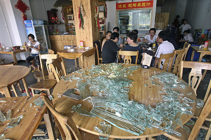 china factory explosion: Residents sit near broken pieces of glass in a restaurant in Nanjing