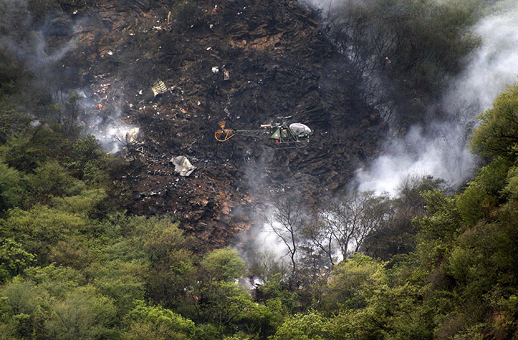 Plane crash in Pakistan: A helicopter flies over the smouldering wreckage of a passenger plane