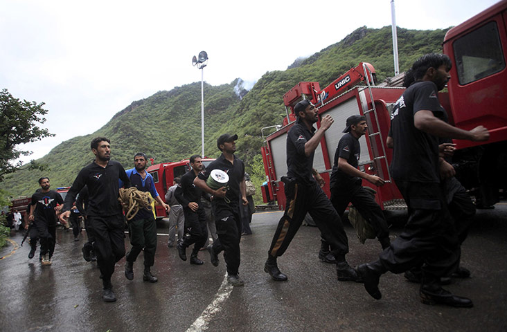 Plane crash in Pakistan: Rescue workers run past fire engines near the site of the wreckage