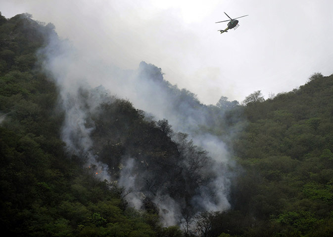 Plane crash in Pakistan: A Pakistani rescue helicopter flies over smoke and wreckage