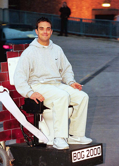 Celeb Style: Robbie: ROBBIE WILLIAMS RIDING A MOBILE TOILET IN CARDIFF, WALES - 1999