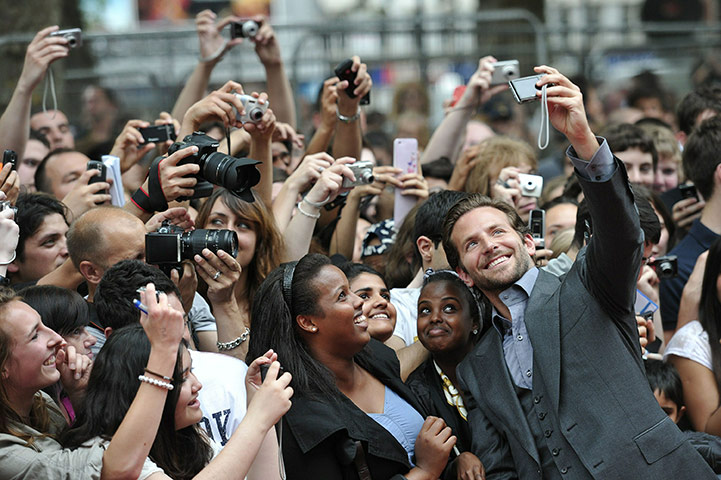 24 hours in pictures: London, UK: Bradley Cooper takes a picture of himself with fans