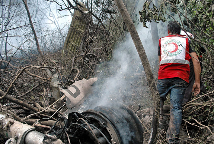 Plane crash in Pakistan: Rescue workers search for bodies amid the wreckage of a plane 