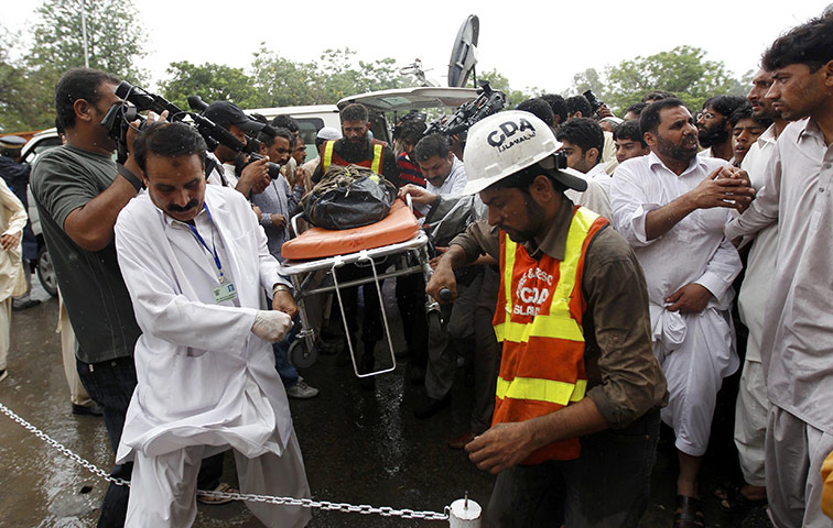 Plane crash in Pakistan: Rescue workers carry the body of a victim of an Airblue passenger plane