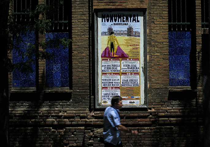 Bullfighting in Barcelona: 2010: A man walks by a banner displaying the bullfight schedule