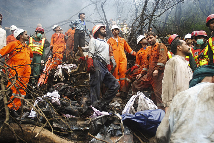 Pakistan plane crash: Rescuers amid the wreckage of a plane 