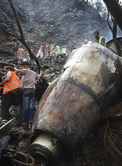 Pakistan plane crash: Pakistani rescuers work in the wreckage of a plane 