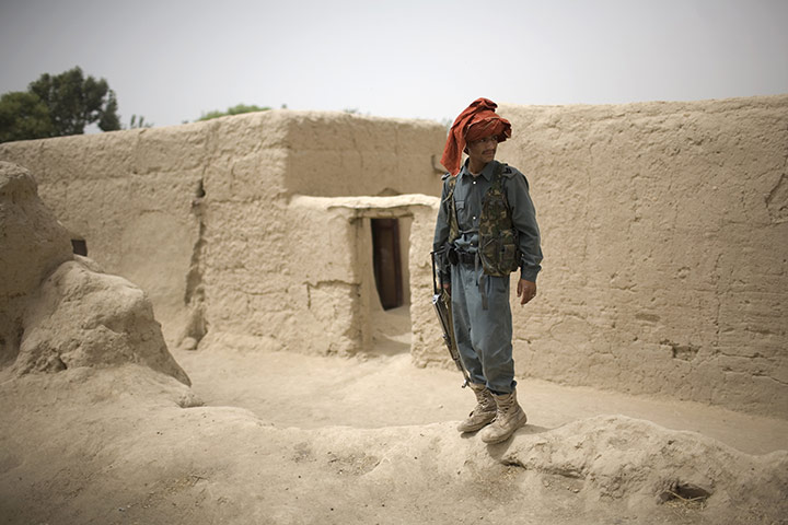 24 hours in pictures: Kandahar, Afghanistan: A police officer stands guard in Samir Kalacha
