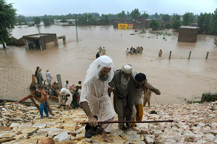 Pakistan floods: Pakistani local residents evacuate in a flood-hit area of Nowshera 