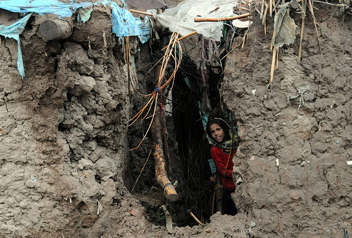 Pakistan floods: A girl looks out from her damaged house in the flood-hit area of Nowshera