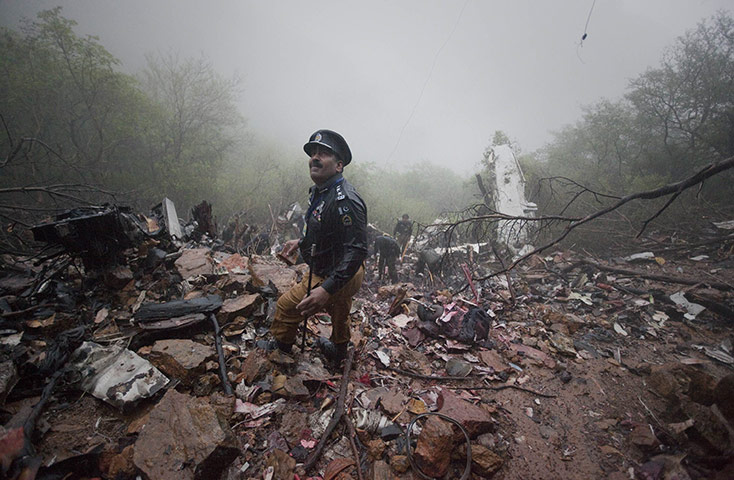 24 hours in pictures: A policeman looks towards the wreckage of an Airblue plane in Pakistan