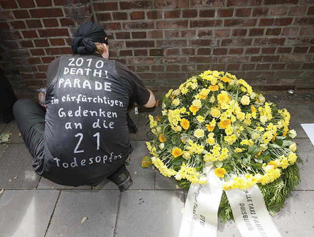 Love Parade: A man places a candle near a wreath from the Duisburg taxi drivers 