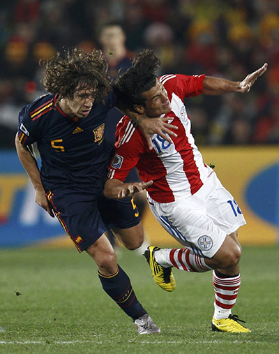 Paraguay versus spain: Spain's Puyol fights for the ball against Paraguay's Valdez 
