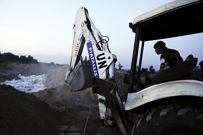 Congo tanker explosion: A UN engineer uses a heavy equipment to bury victims' bodies 