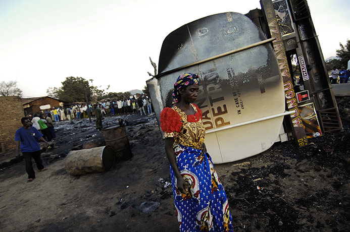 Congo tanker explosion: A woman walks past the burned out wreckage of a tanker truck 